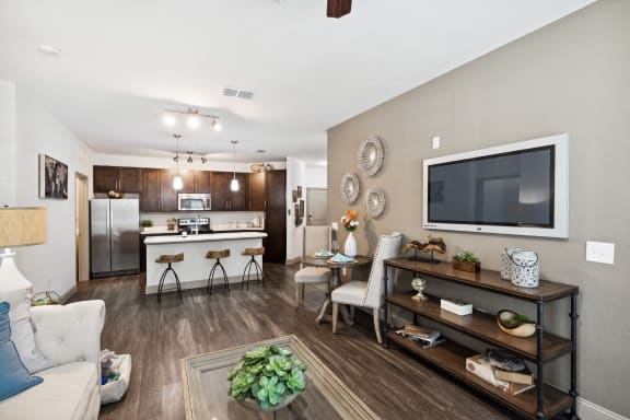 our apartments offer a living room with a couch a coffee table and a flat screen tv