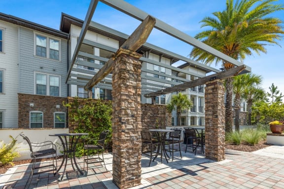 a patio with a pergola and tables and chairs