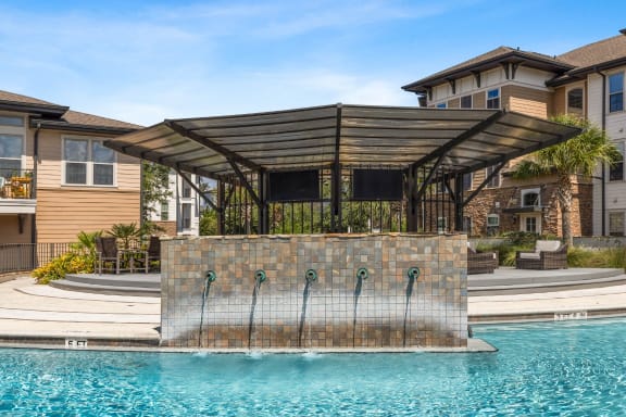 a pergola with a waterfall in front of a pool