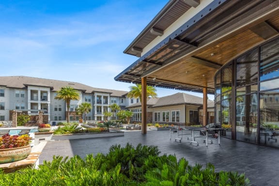 a patio with tables and chairs in front of a building