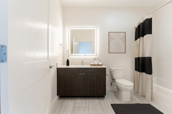 a bathroom with white walls and a black and white shower curtain at The Box, Richmond, VA, 23224