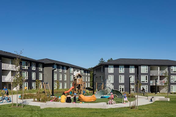 A playground area in front of apartment buildings.