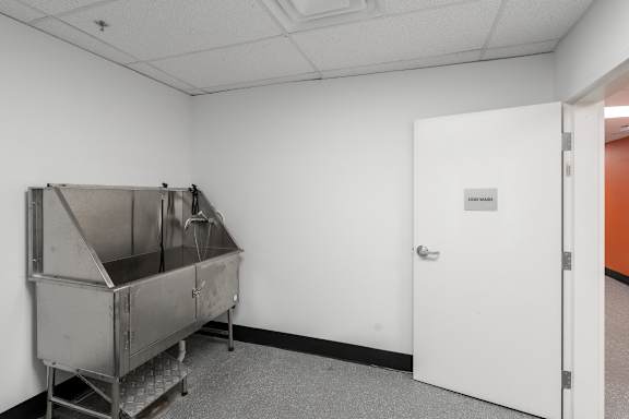 A large metal container sits in a white room next to a door.