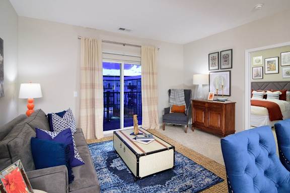 a living room with a couch and a chair and a bedroom with a bed