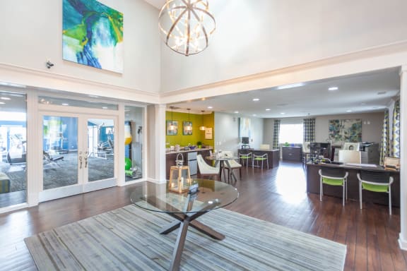 A modern open plan living and dining room with a glass table and chairs. at Chinoe Creek Apartments, Lexington, KY, 40502