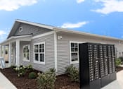 Thumbnail 3 of 10 - A grey house with a black mailbox in front.