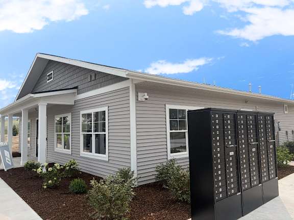 A grey house with a black mailbox in front.