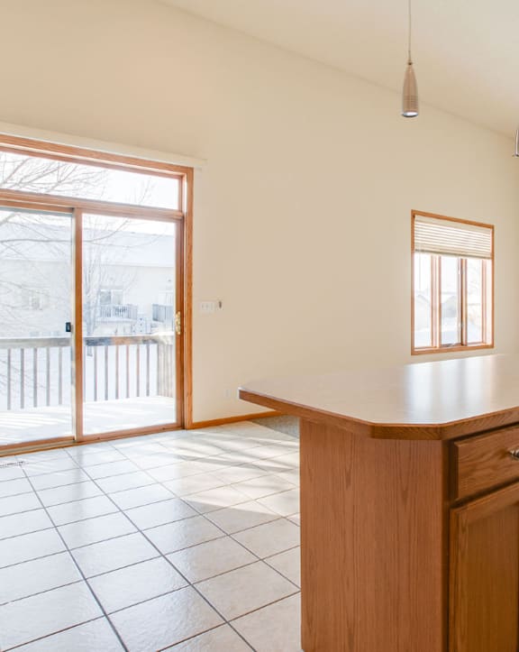 A kitchen with a wooden counter and tile floor.