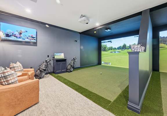 A room with a golf simulator and a couch. at Maison Apartments, Westerville, Ohio