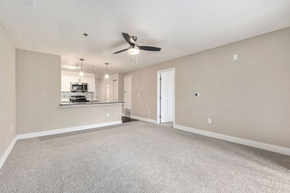 Living room with carpet leading to kitchen at Eagle Ridge Apartment Homes,  Michigan 49685