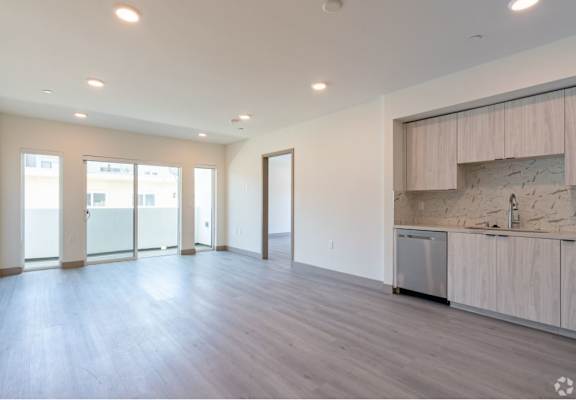 Living Area with Custom Cabinets, Wood Vinyl Floors & Sliding Glass Doors to Private Balcony