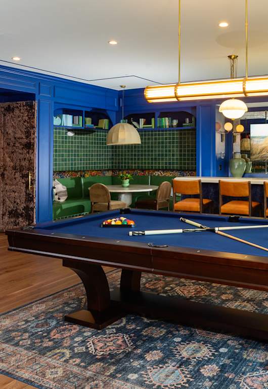 a lounge area with couches and a coffee table in front of a pool