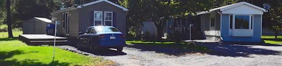 A blue car is parked in front of a house.