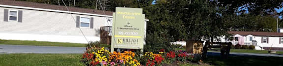 A sign for Mountainview Estates is in front of a building and a tree.