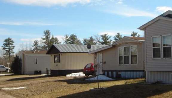 3 grey houses with piles of snow nearby