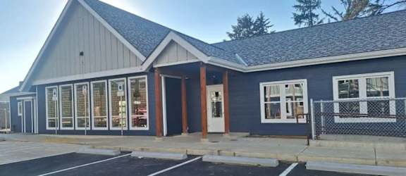 A small building with a parking lot in front.