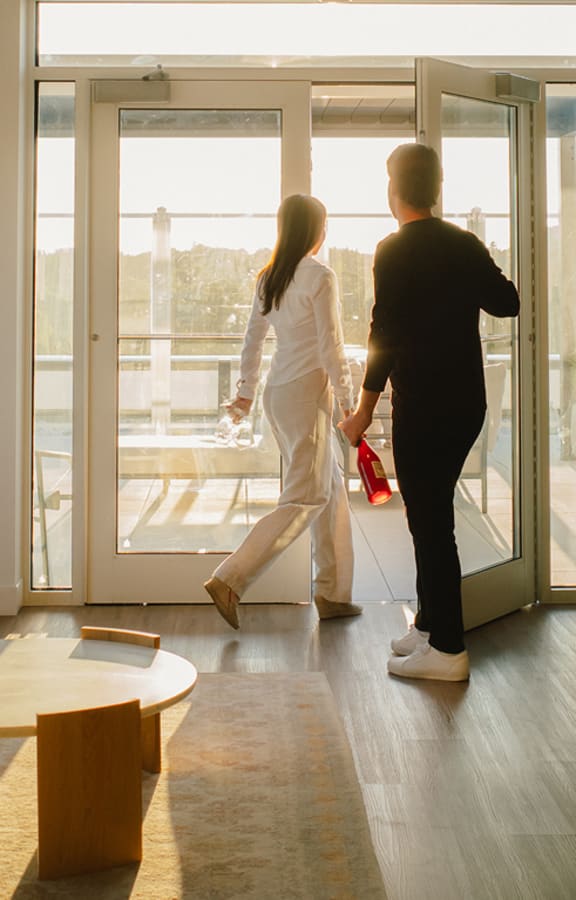 A man and a woman are walking through a glass door.