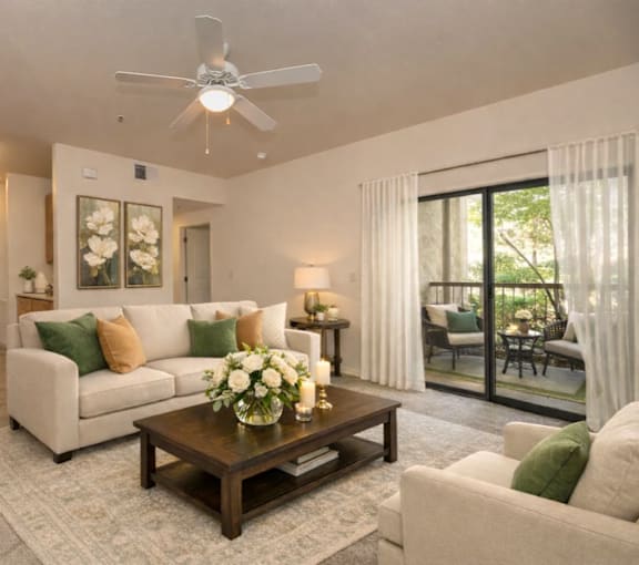 A living room with a white couch, a coffee table, and a ceiling fan.
