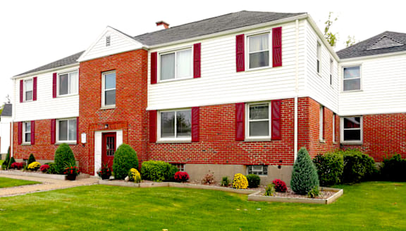 A red and white house with a green lawn in front.