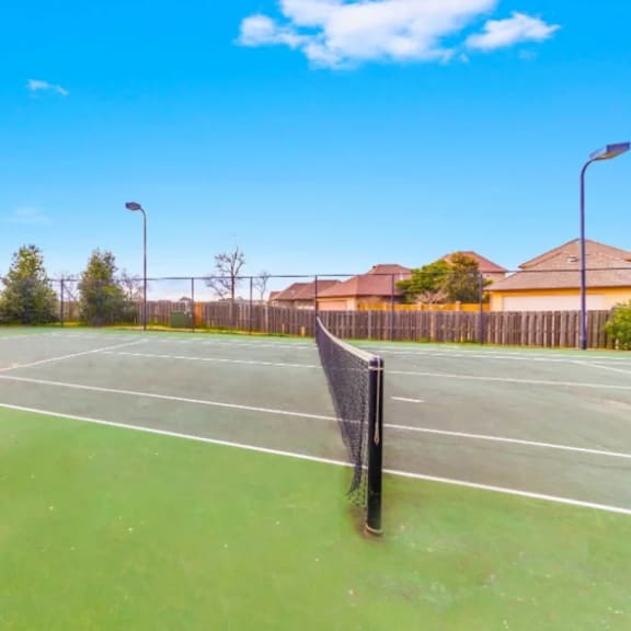 A tennis court with a net and a sign on it.