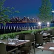 A restaurant with a view of the city skyline at night.