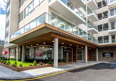 A modern building with a brown entrance and glass windows.