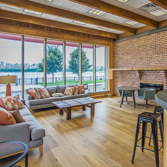 A living room with a grey couch and a wooden floor.