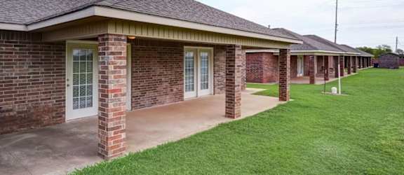a row of brick buildings with a grassy area in front of them