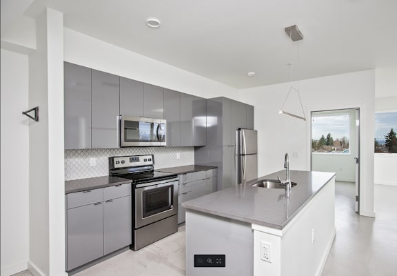 a modern kitchen with stainless steel appliances and white counter tops