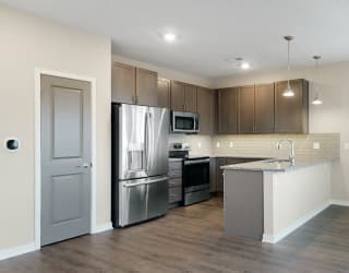 The 2 bedroom Marigold with den floor plan at WH Flats features an open kitchen with granite countertops and large peninsula.