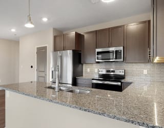 The 2 bedroom Marigold with den floor plan at WH Flats features an stainless steel appliances, granite countertops and large peninsula.