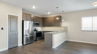 The 2 bedroom Marigold with den floor plan at WH Flats features an open kitchen with granite countertops and large peninsula.