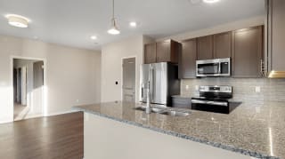 The 2 bedroom Marigold with den floor plan at WH Flats features an stainless steel appliances, granite countertops and large peninsula.