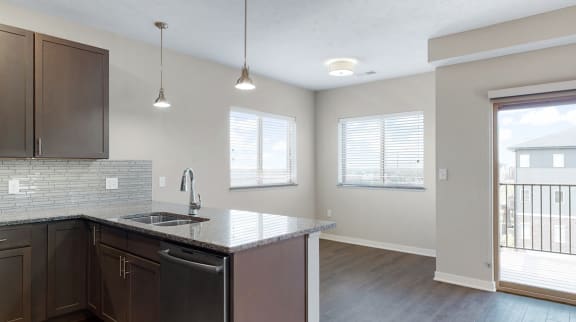 The 2 bedroom Marigold with den floor plan at WH Flats features an open eat-in kitchen area with granite countertops and large peninsula.