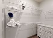 Thumbnail 6 of 11 - a large walk in closet with a large mirror and a dresser