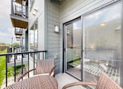 Thumbnail 8 of 11 - a balcony with a table and chairs and a sliding glass door