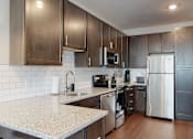 Thumbnail 1 of 11 - a kitchen with dark wood cabinets and white granite countertops