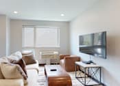 Thumbnail 2 of 11 - a living room with a couch and a coffee table in front of a tv