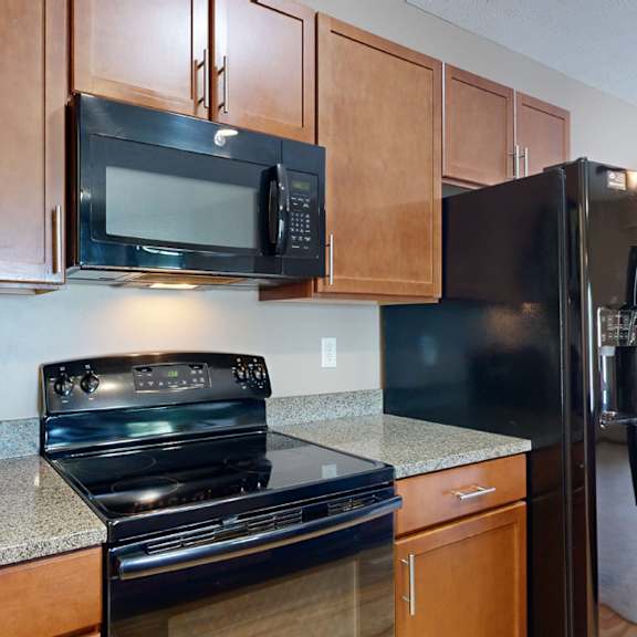 a kitchen with black GE appliances and granite counter tops