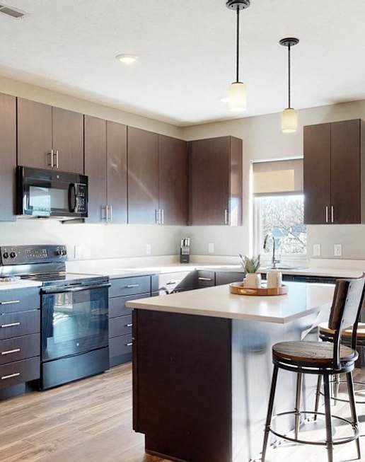 Furnished apartment kitchen with dark finish style and all black kitchen appliances
