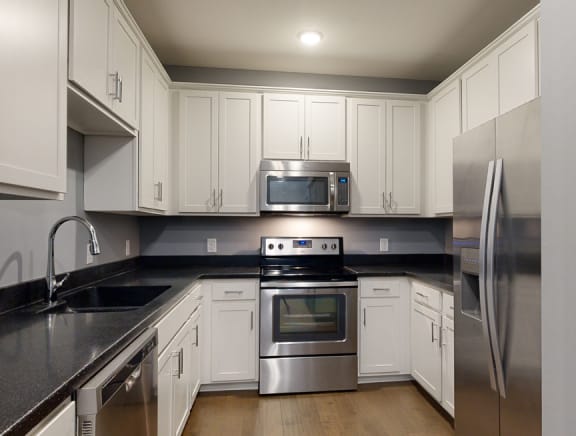 a kitchen with white cabinets and stainless steel appliances