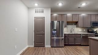 This 2 bedroom Hibiscus floor plan features an open kitchen with neutral gray cabinets, light granite countertops, and a large pantry.