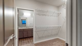 The master bedroom in the Hibiscus floor plan features a spacious walk-in closet.