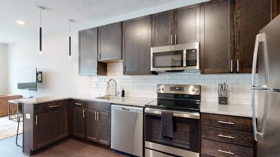 a kitchen with dark wood cabinets and stainless steel appliances