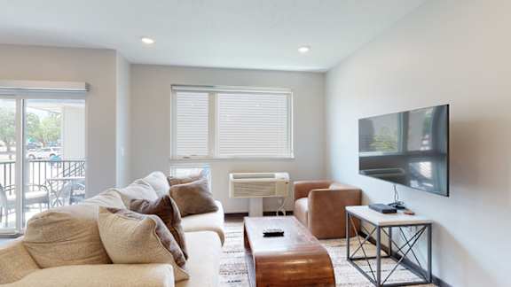 a living room with a couch and a coffee table in front of a tv
