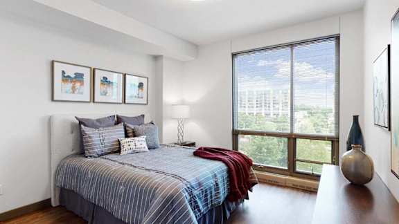a bedroom with a bed and a floor to ceiling window