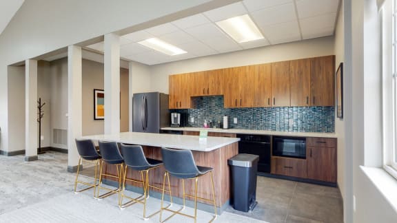 Community clubhouse shared kitchen with large island and bar stools