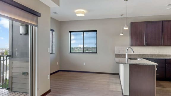 The 2 bedroom Snowdrop with den floor plan at WH Flats features an open eat-in kitchen area with granite countertops and large peninsula.