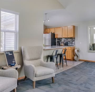 Lounge space with chairs near the kitchen in the clubhouse at Skyline View