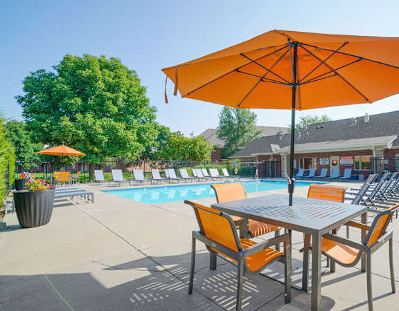 a swimming pool surrounded with lounge chairs and a few tables with umbrellas and chairs